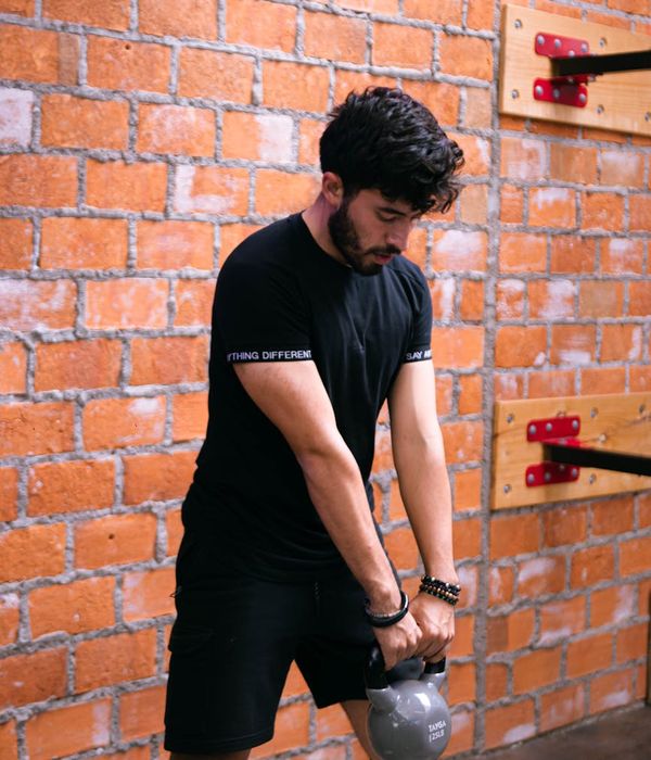 Man practicing strength exercises in a dark premium gym environment